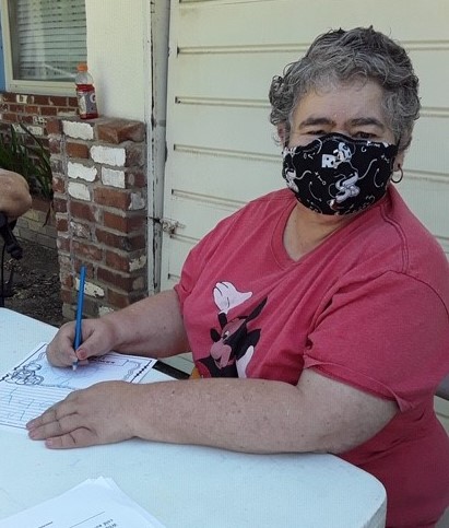 Student Brenda works on a color sheet at her home.